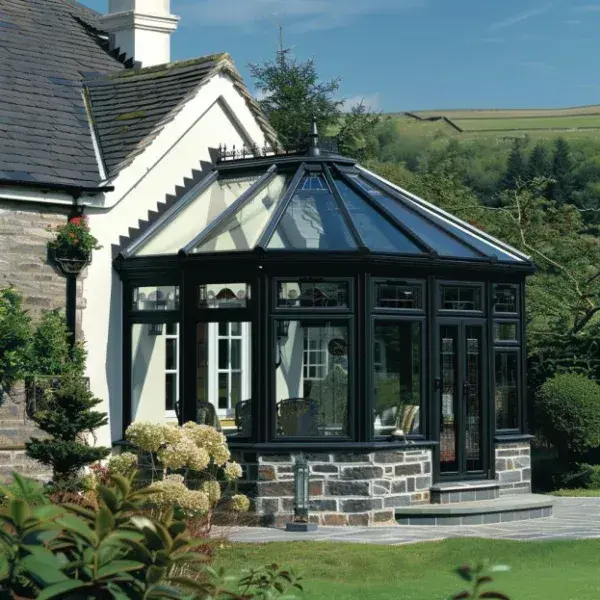 Black-framed glass conservatory roof on a stone house from the Ultimate Home Solutions gallery