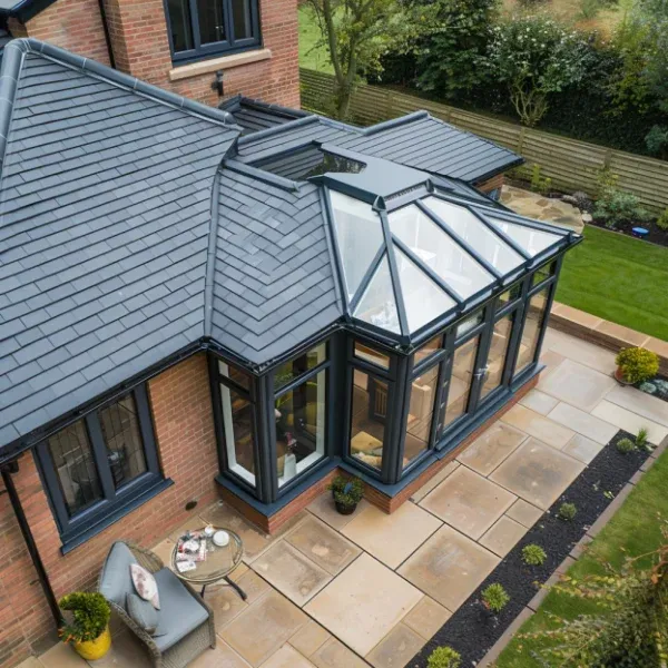 Conservatory with grey tiled roof sections and a glazed centre